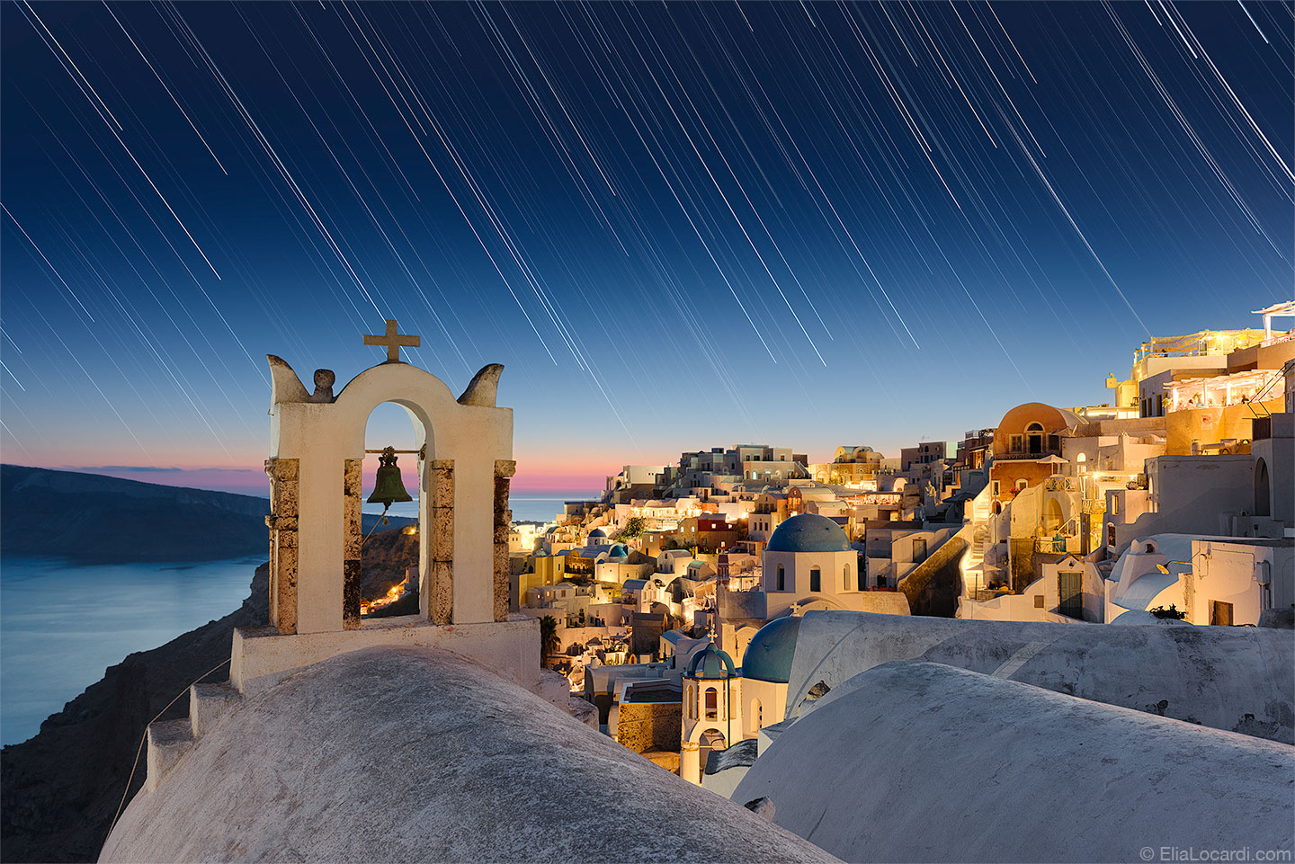 As the stars dance above the enchanting town of Oia Santorini, the island paradise of the Aegean Sea.