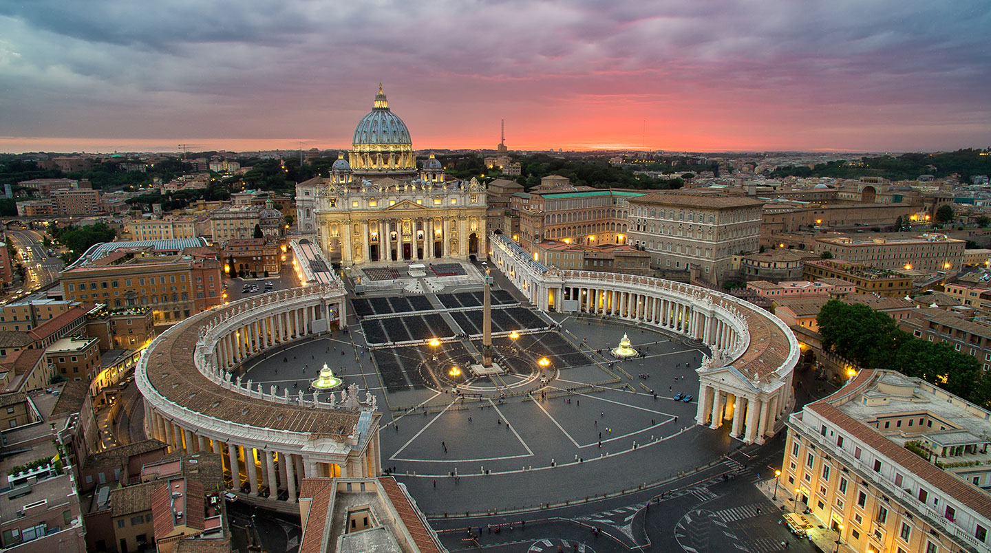 (A spectacular view from above, as the sky lights up behind The Vatican in Rome.)